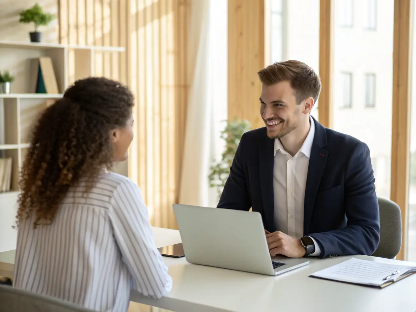 Ein professionelles Büroambiente, in dem ein Personalvermittler und ein Kandidat in einem freundlichen Gespräch sitzen, um die individuelle Vermittlung hervorzuheben.